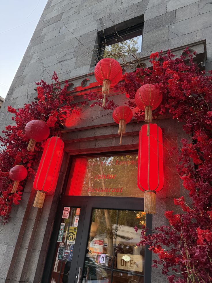 Lantern-lined entrance framed with red blossoms